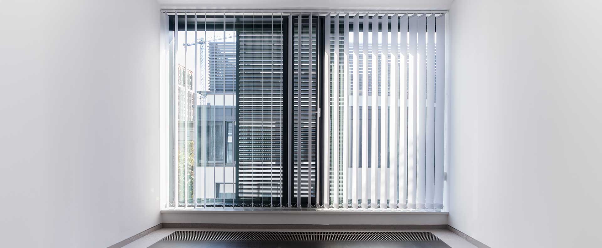 Sleek vertical blinds in a modern office setting, with a glimpse of the cityscape outside.