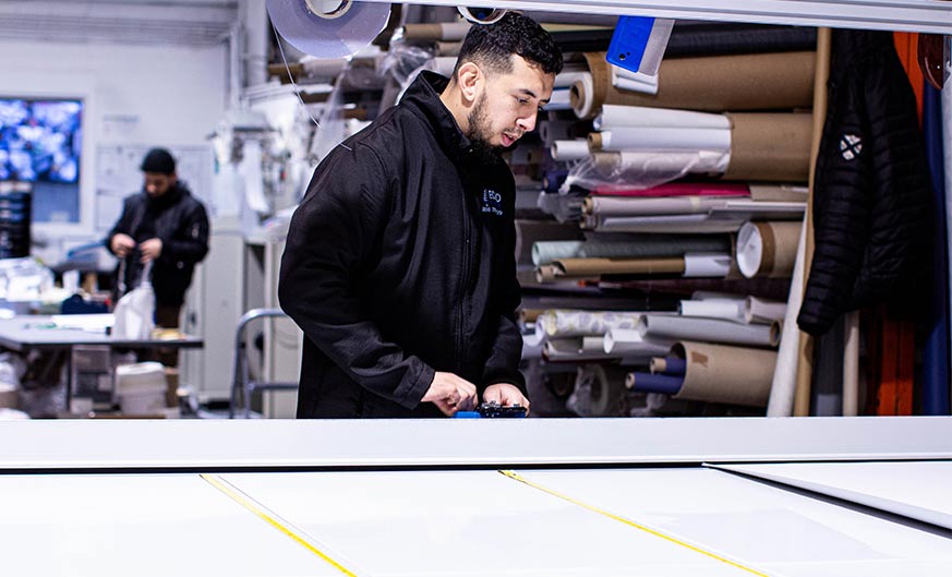 A focused Ecco Blinds team member meticulously crafting blinds as part of Our Guarantee.